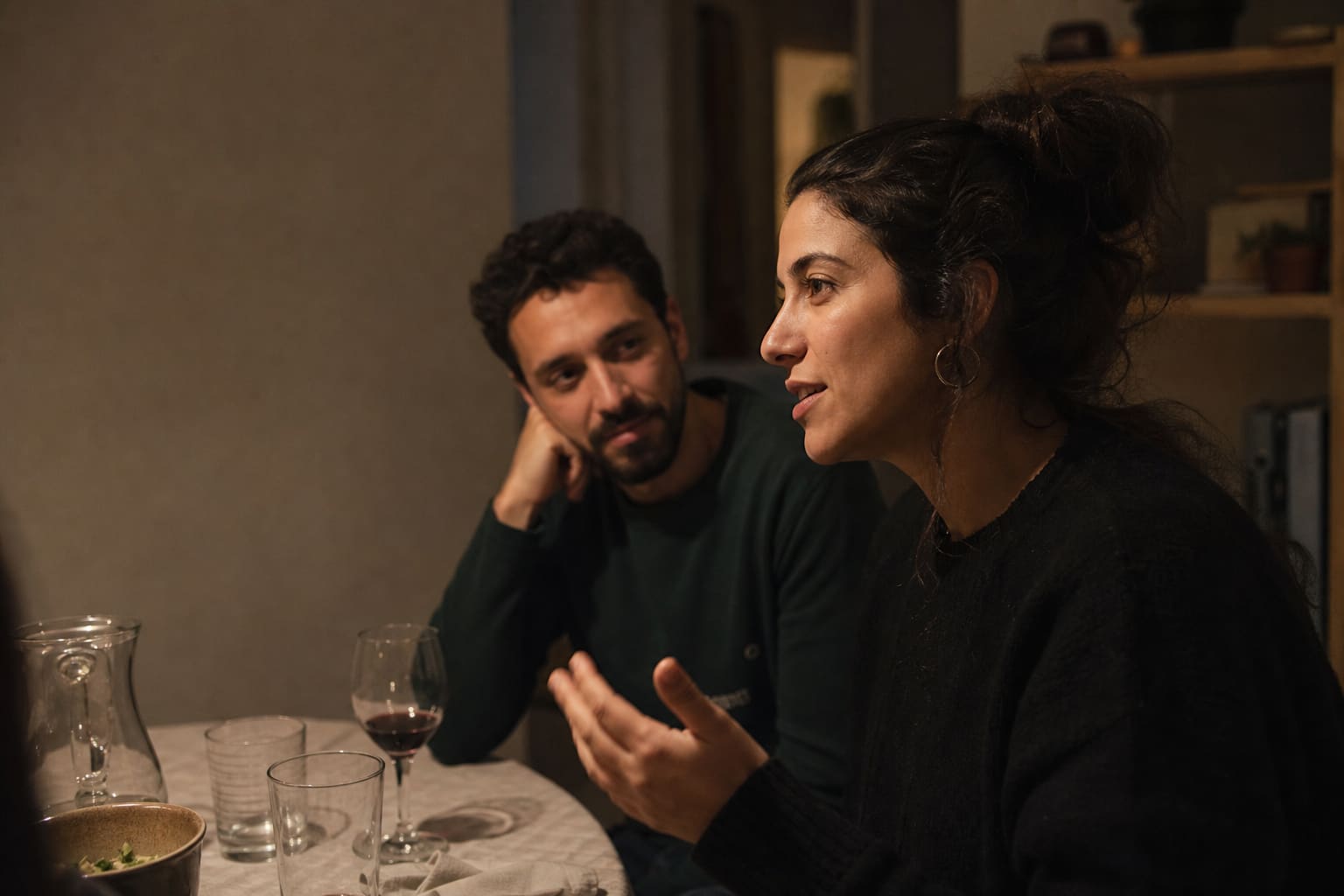 Mujer hablando con naturalidad mientras comparte una historia durante una cena informal