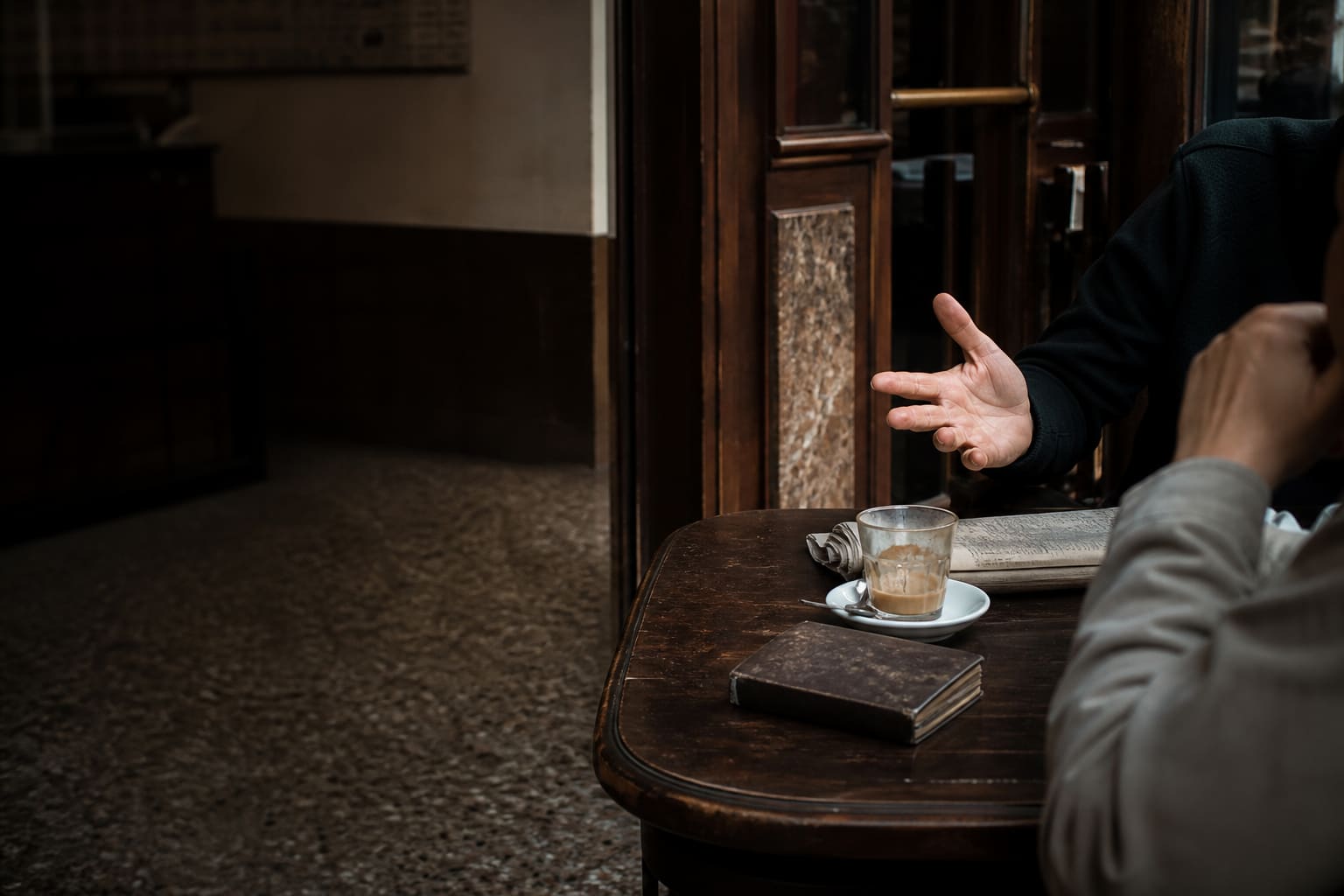 Conversación cotidiana con gestos en un café tradicional de Buenos Aires