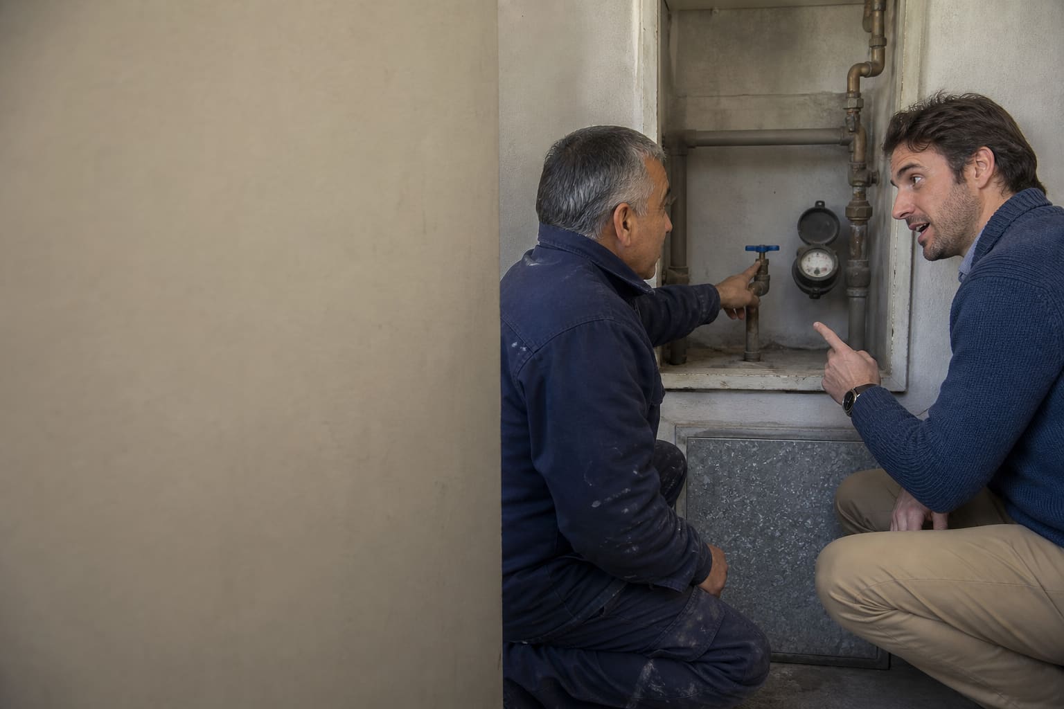 International resident using Spanish while learning about an apartment utility valve