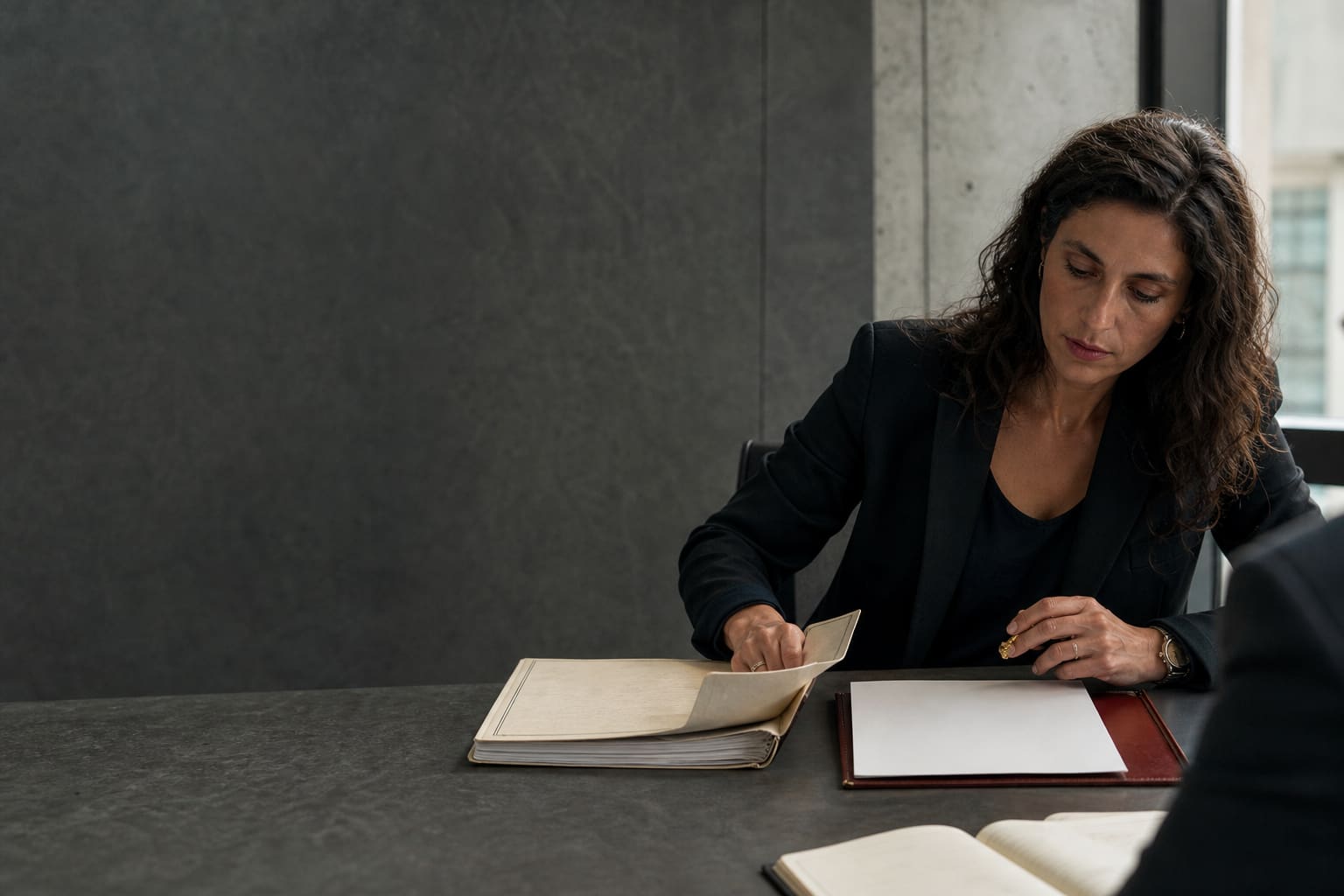 Legal professional preparing documents for a bilingual due-diligence meeting