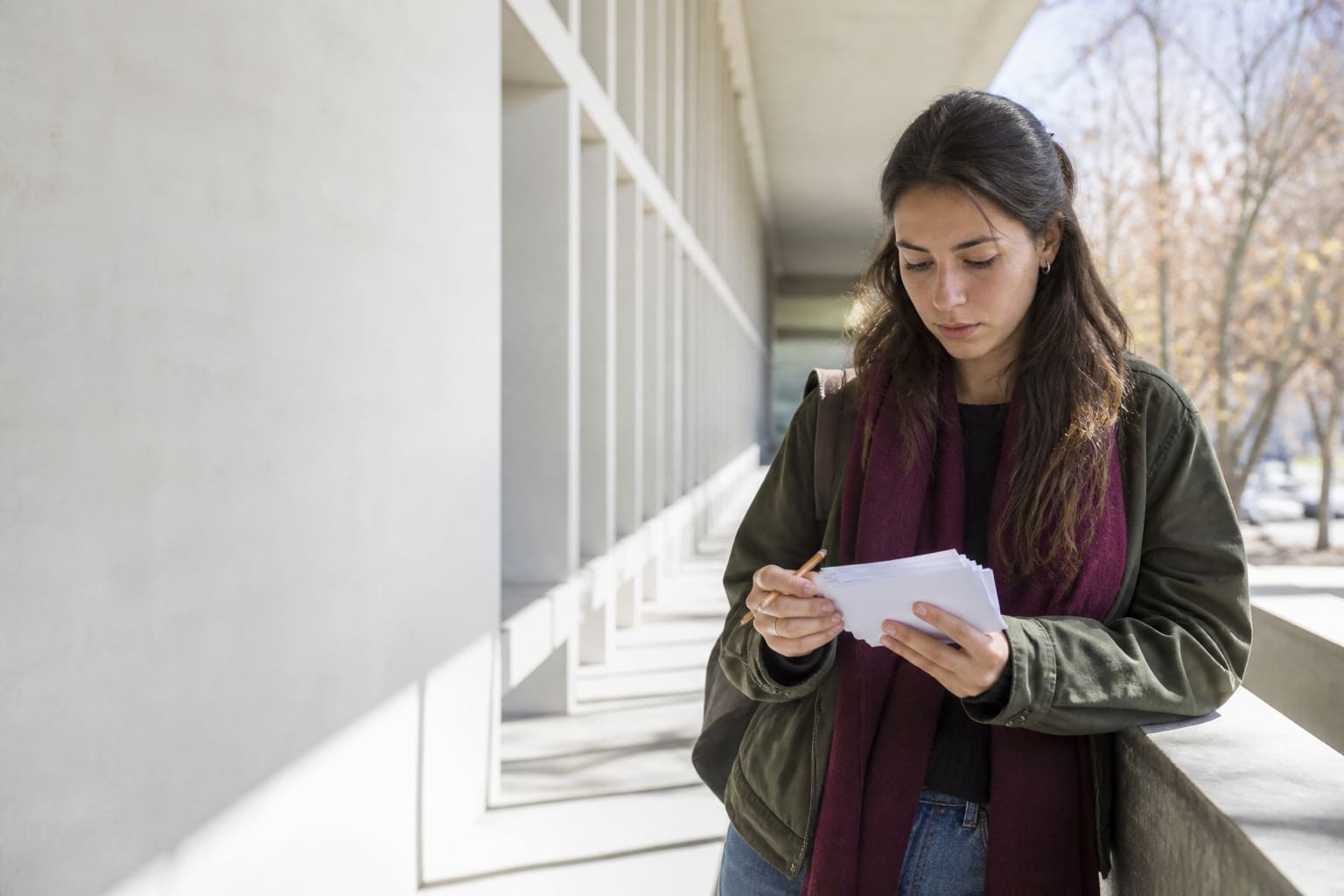 Estudiante universitaria repasa tarjetas de práctica antes de una evaluación de inglés en un campus mendocino