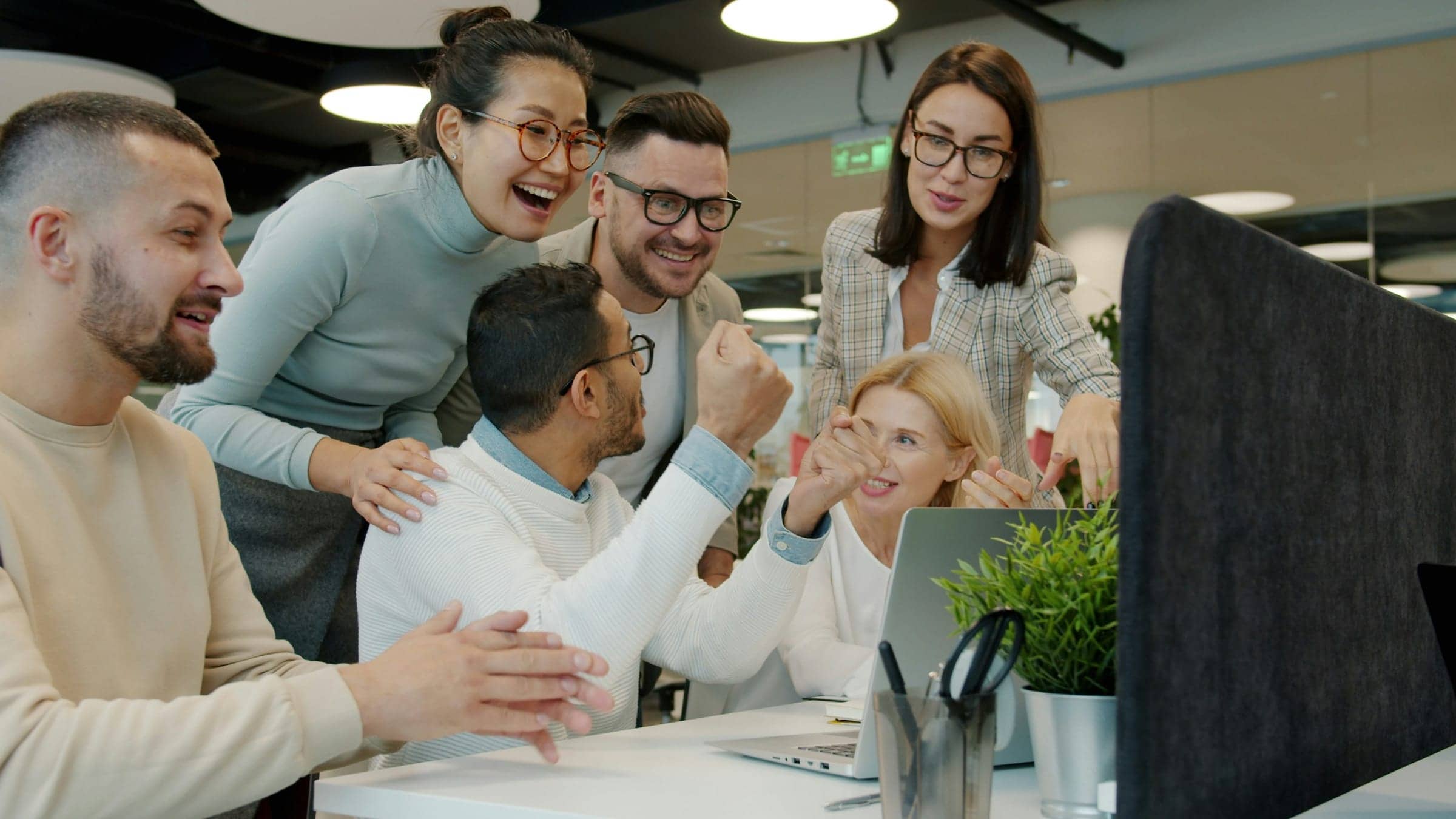 Equipo de customer success trabajando en inglés en oficina moderna y colaborativa