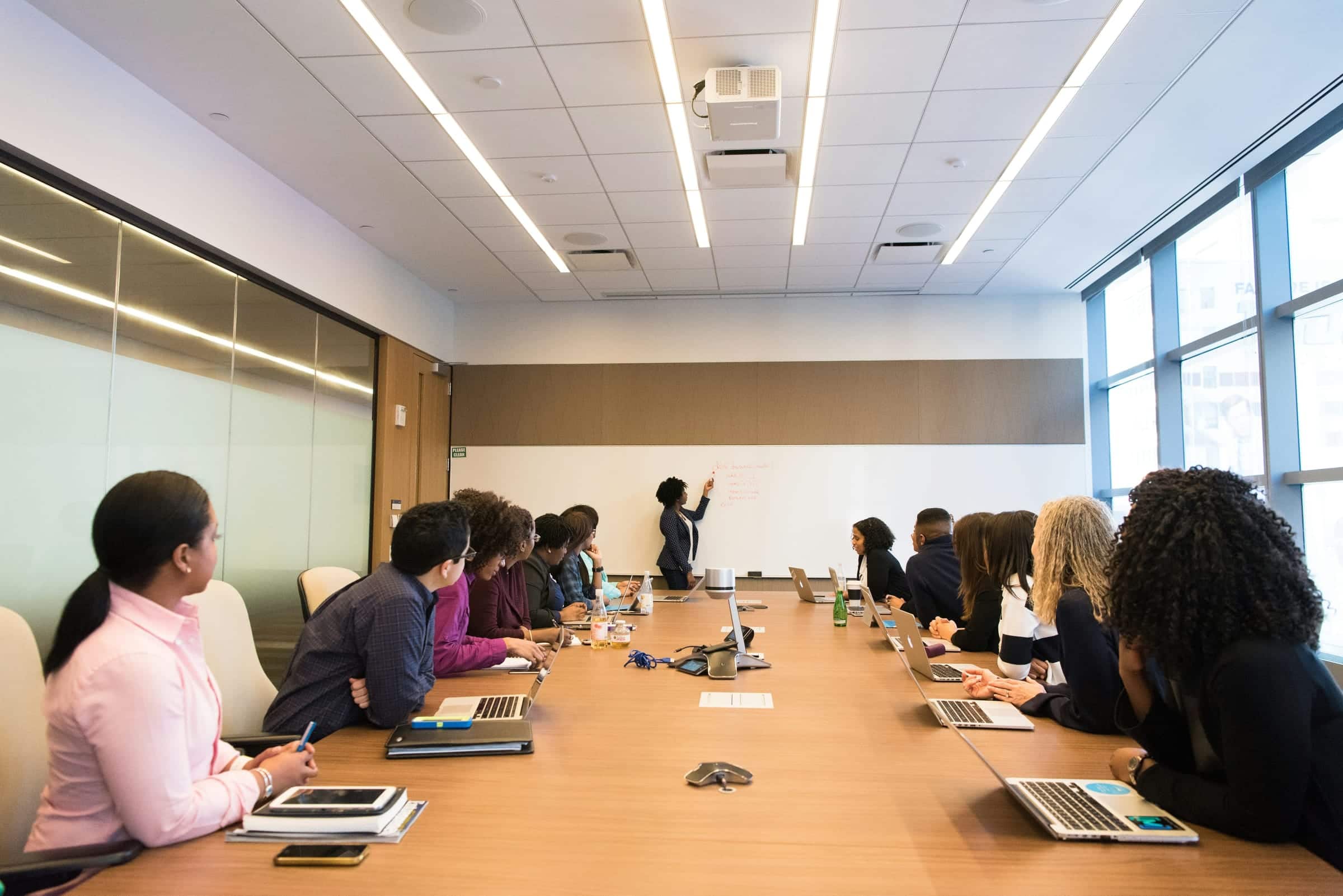 Gerente ejecutivo conduciendo una reunión de negocios en inglés en sala de directorio